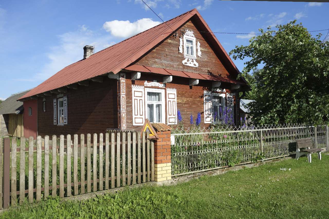 A wooden house with elaborate white ornaments in Podlaskie Poland