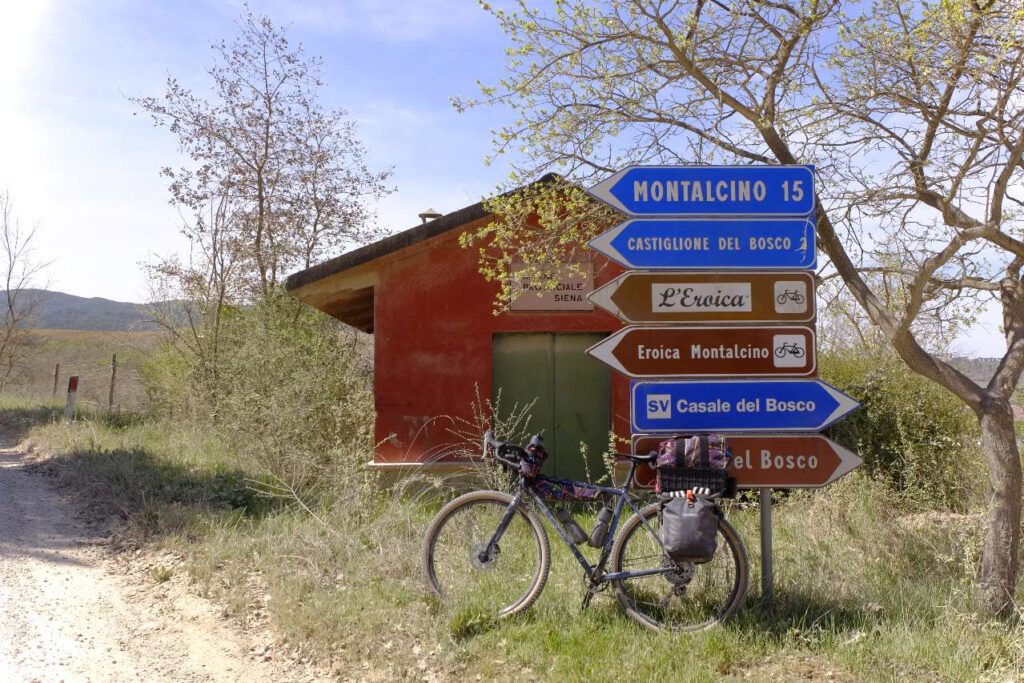 Gravelbike lehnt an Schildern zur Gravelstrecke L'Eroica in der Toskana