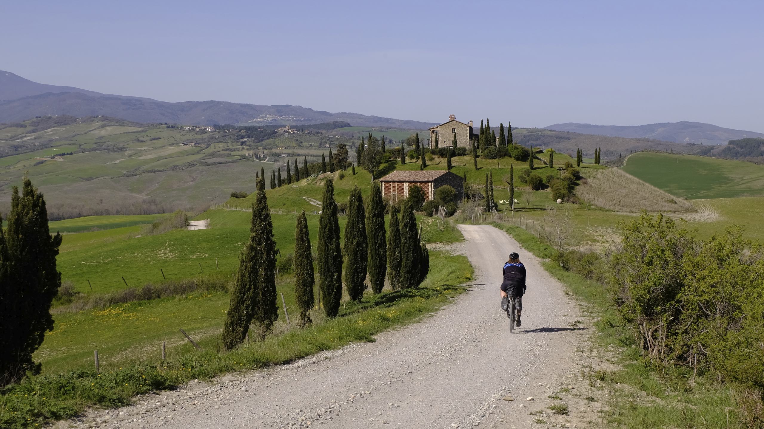 Gravel biker on gravel road to a villa in Tuscany