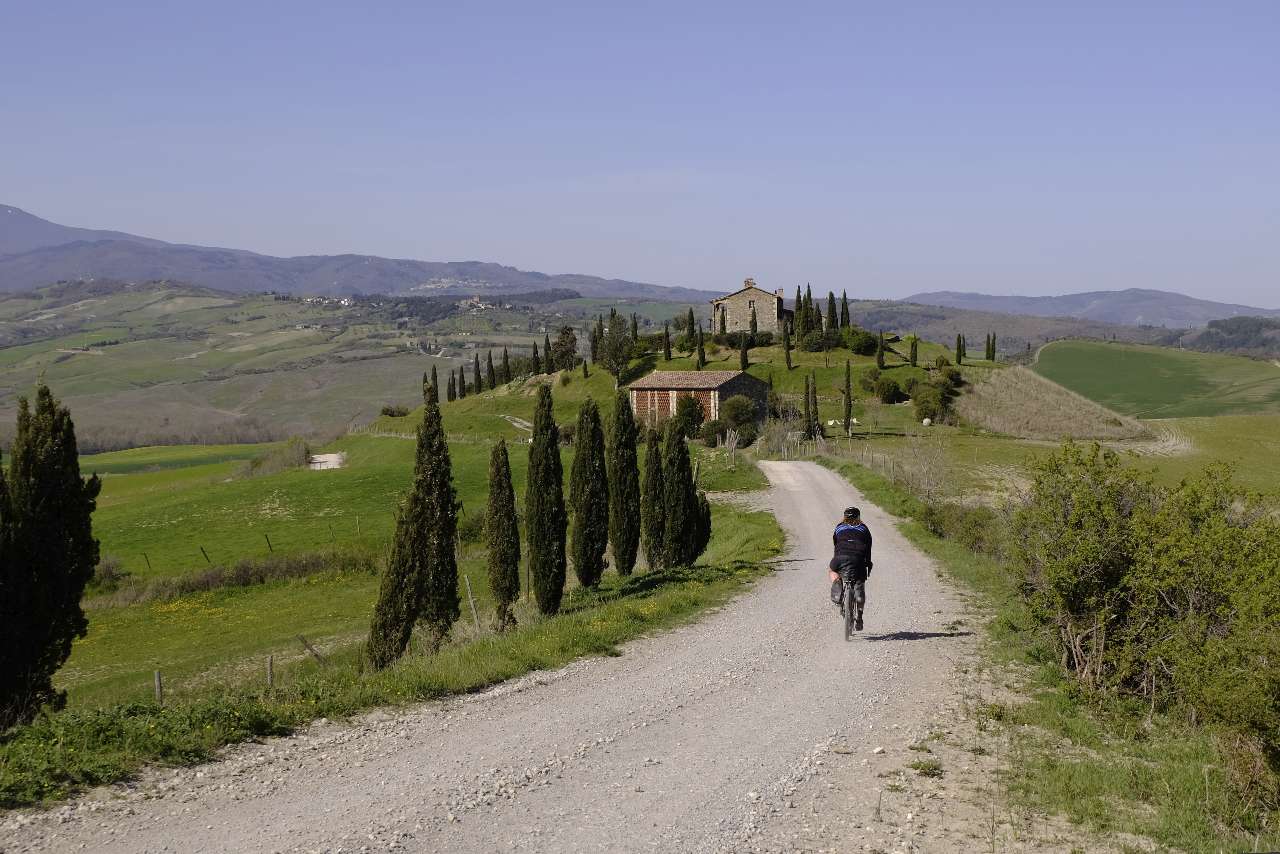 Gravel biker on gravel road to a villa in Tuscany