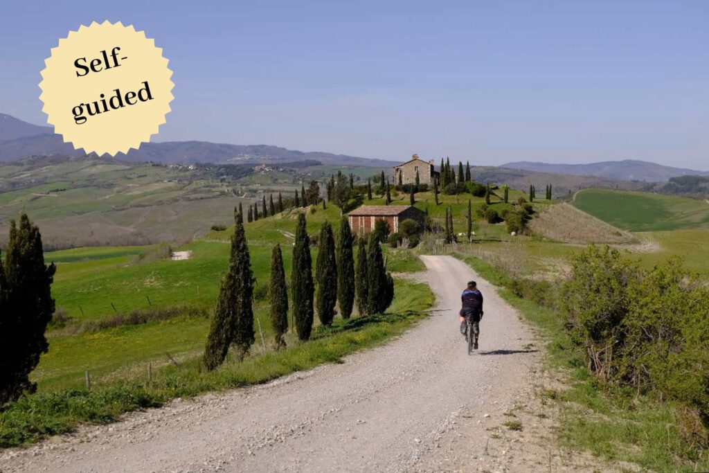 Gravel biker on gravel road to a villa in Tuscany